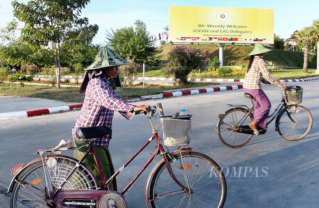 Warga melintasi baliho yang dipasang untuk menyambut KTT ASEAN di Naypyidaw, Myanmar, Senin (10 November 2014). Alih-alih <i>warga melintasi baliho</i>, frasa tersebut dapat diganti menjadi <i>warga melintas di sekitar baliho </i>atau <i>warga melintasi jalan yang terdapat baliho</i> agar kalimat menjadi baik dan benar. 