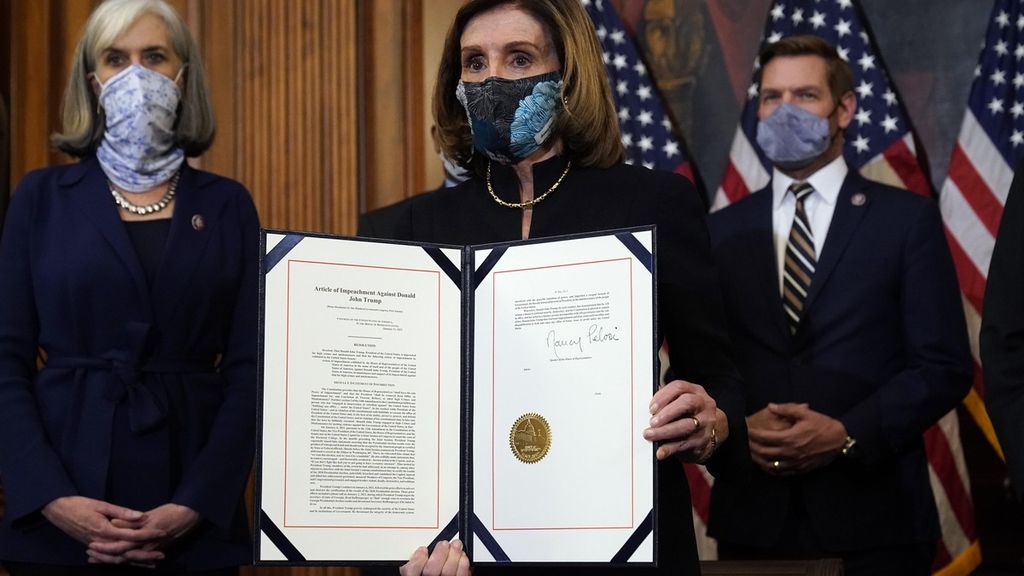 Ketua Kongres AS Nancy Pelosi memperlihatkan dokumen pemakzulan terhadap Presiden Donald Trump yang baru saja ia tanda tangani di Gedung Capitol, Washington, AS, 13 Januari 2021. 