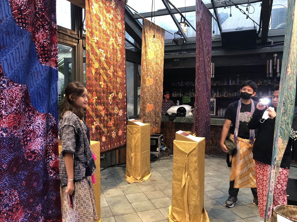 Pengunjung Pesta Wastra berfoto di antara kain dengan motif besutan pesohor Tara Basro, Eva Celia, Arawinda Kirana, dan Rachel Amanda.