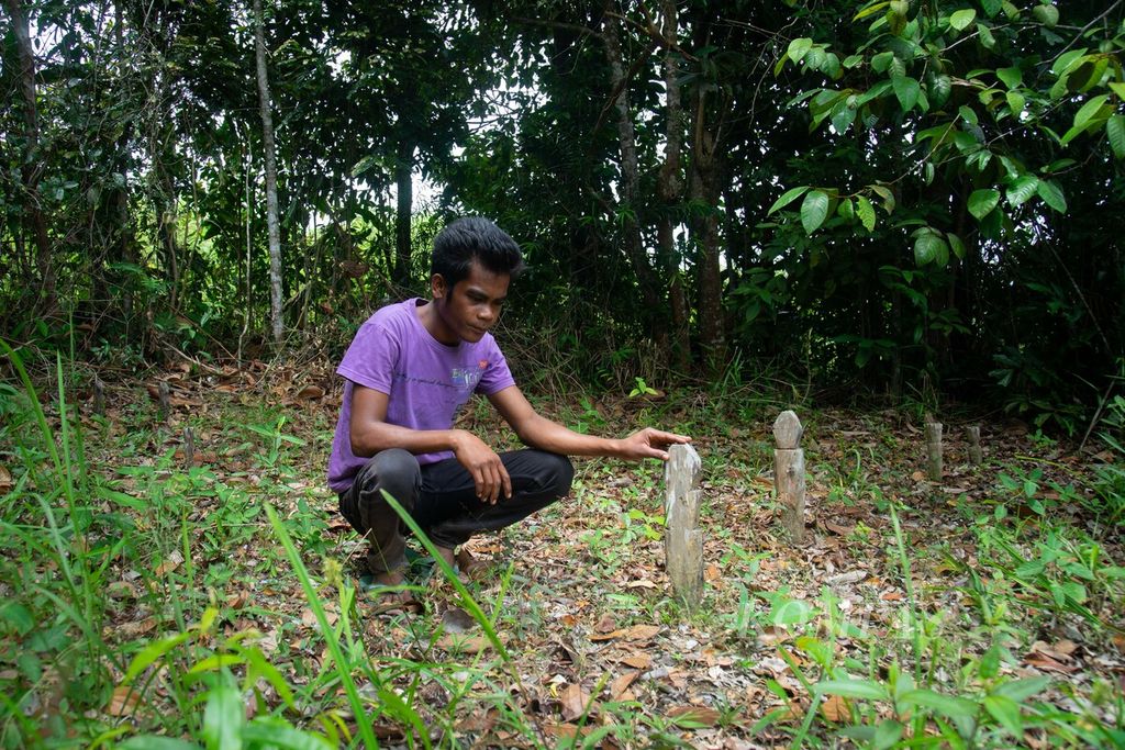 Salah satu suku Orang Darat, Baru (24), menunjukkan makam leluhurnya di Kampung Sungai Sadap, Kelurahan Rempang Cate, Kecamatan Galang, Kota Batam, Kepulauan Riau, Jumat (5/8/2022).