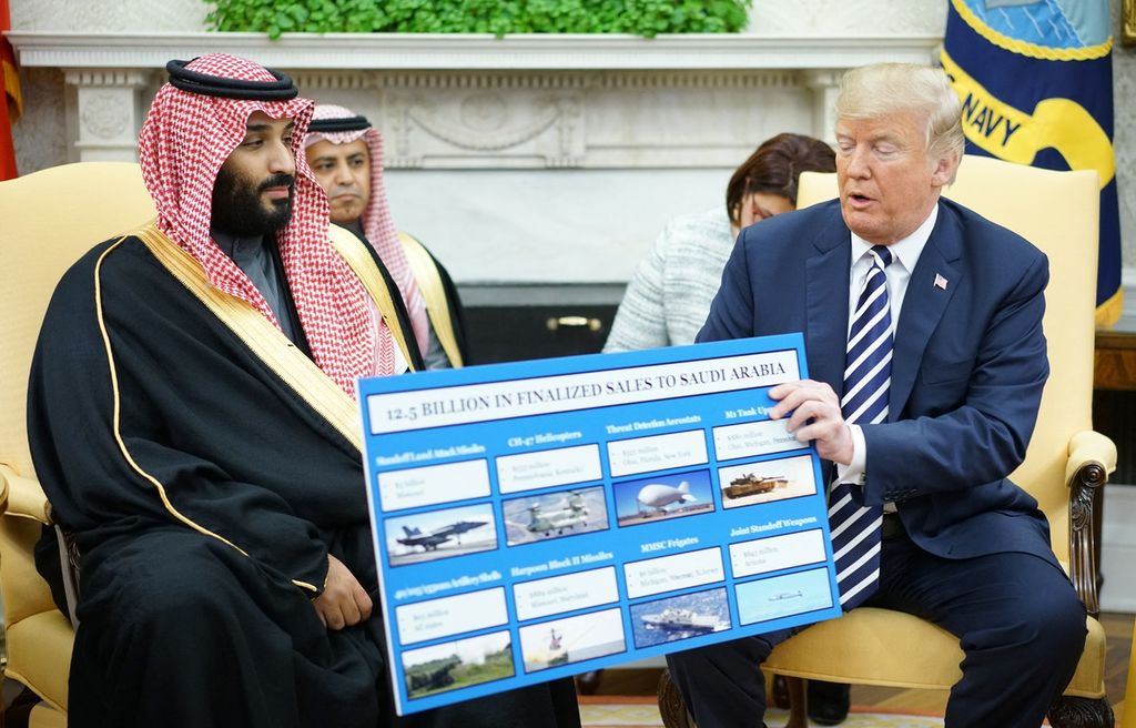 Foto yang diambil pada 20 Maret 2018 memperlihatkan mantan Presiden Amerika Serikat Donald Trump (kanan) tengah memperlihatkan gambar persenjataan militer yang telah dijual ke Arab Saudi pada putra mahkota Kerajaan Arab Saudi Pangeran Mohammed bin Salman (kiri) di Gedung Putih, Washington, AS. 