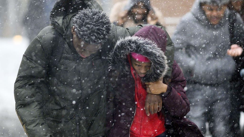 Pejalan kaki menyeberang jalan selama hujan salju lebat di pusat kota Manhattan, 30 Januari 2019, di New York City. Kondisi ini meningkatkan ketakutan radang dingin dan hipotermia bagi tunawisma.