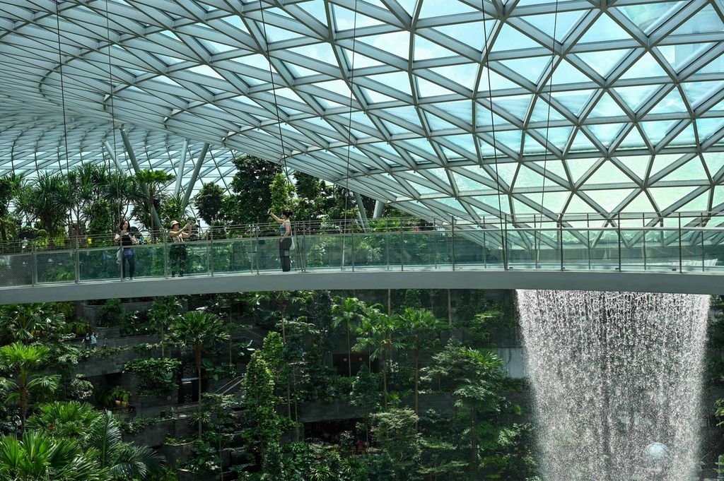 Sejumlah warga mengambil gambar dari jembatan pemantau Rain Vortex di Jewel Bandara Changi Singapura pada 7 Desember 2022 lalu.