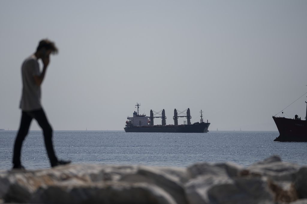 Seorang pria berjalan dengan latar kapal kargo berbendera Panama, Lady Zehma, yang buang sauh di Laut Marmara, Istanbul, Turki, 1 Oktober 2022.