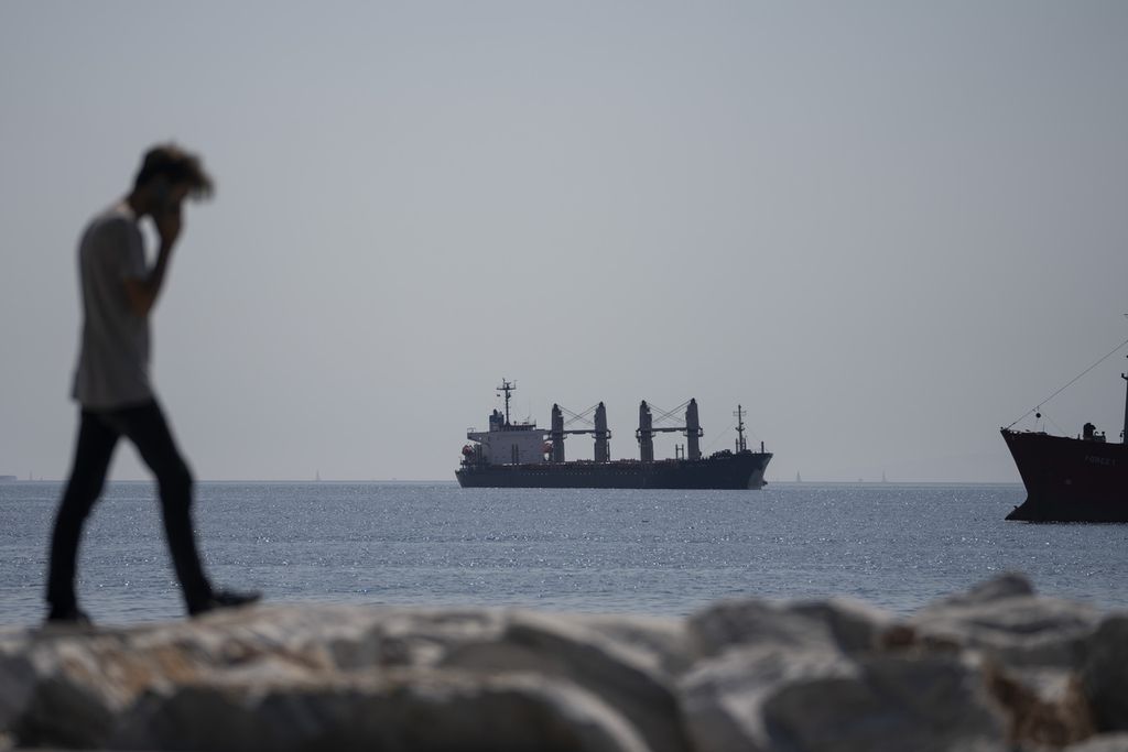 Seorang pria berjalan dengan latar kapal kargo berbendara Panama, Lady Zehma, yang buang sauh di Laut Marmara, Istanbul, Turki, 1 Oktober 2022. Pemerintah Rusia menyebut tidak menjamin keamanan kapal-kapal kargo pengangkut gandum Ukraina setelah menangguhkan keikutsertaan dalam Kesepakatan Laut Hitam mulai 29 Oktober 2022. 