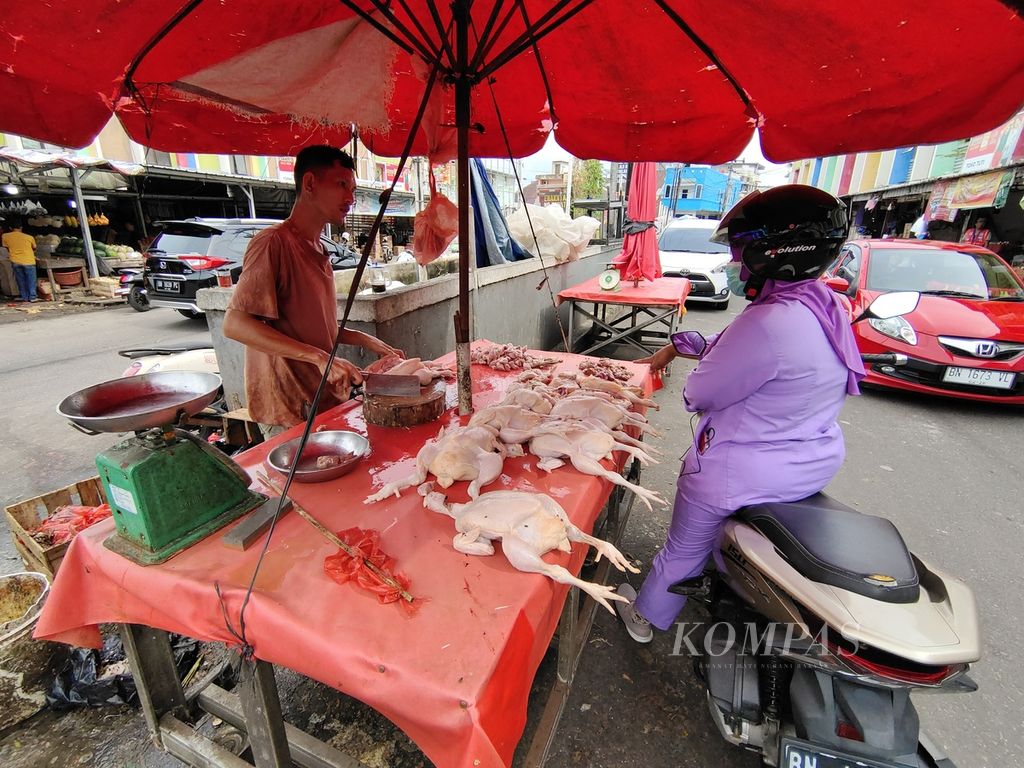 Penjual ayam potong di Pasar Besar Pangkal Pinang, Boy (28), melayani pembeli, Rabu (24/4/2024). 