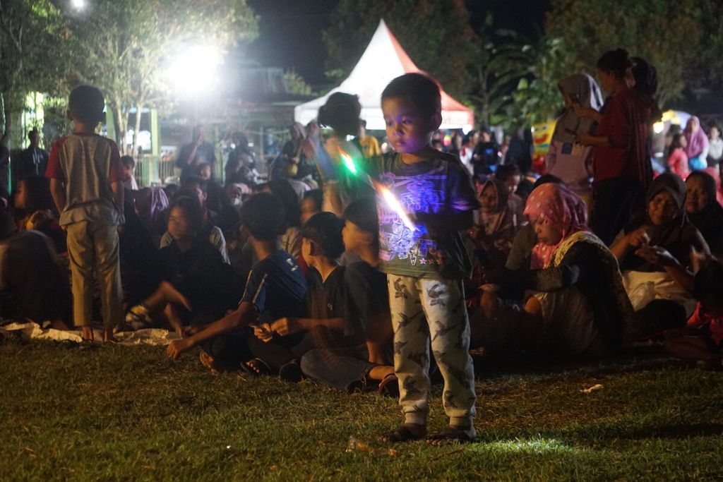 Anak-anak bermain di sela-sela pemutaran film pada acara <i>layar tanjleb</i> dalam rangkaian Festival Film Purbalingga di Desa Toyareja, Kabupaten Purbalingga, Jawa Tengah, Sabtu (22/7/2023) malam.