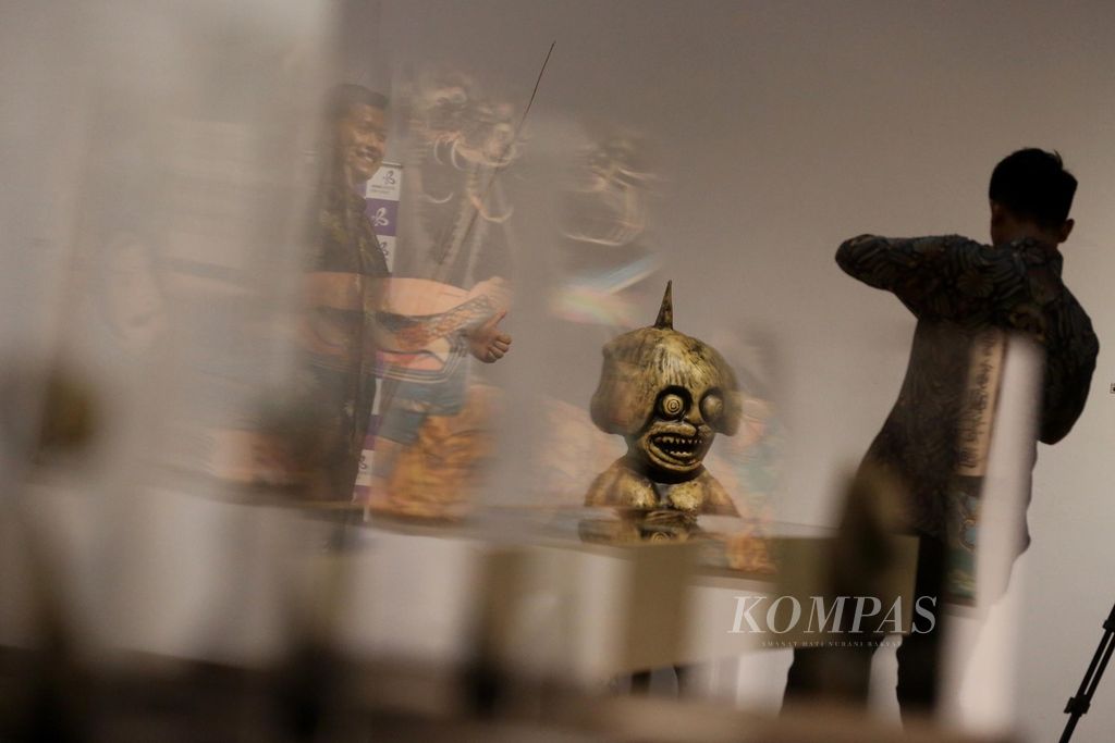 Pengunjung berpose di samping patung hantu Jepang pada pameran Yokai Parade hasil kerja sama antara Bentara Budaya dengan Japan Foundation dan Kedutaan Jepang di Jakarta, Kamis (16/6/2022). Pameran yang menampilkan sejumlah profil hantu monster asal Jepang tersebut akan berlangsung hingga 27 Juni.