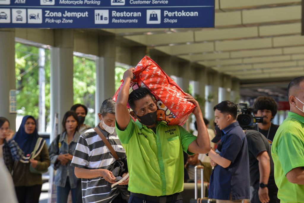 Seorang porter membawa barang bawaan penumpang kereta di Stasiun Pasar Senen, Jakarta Pusat, Selasa (11/4/2023). Menjelang Lebaran 2023, para penumpang di Stasiun Pasar Senen belum mengalami lonjakan. 