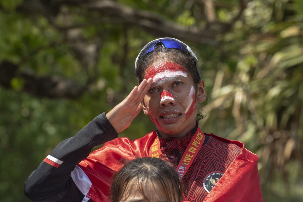 Pelari putri Indonesia, Odekta Elvina Naibaho, memberi hormat saat upacara penyerahan medali maraton SEA Games 2023 di kawasan situs warisan budaya dunia UNESCO Angkor Wat, Siem Reap, Kamboja, Sabtu (6/5/2023). Odekta berhasil meraih medali emas.