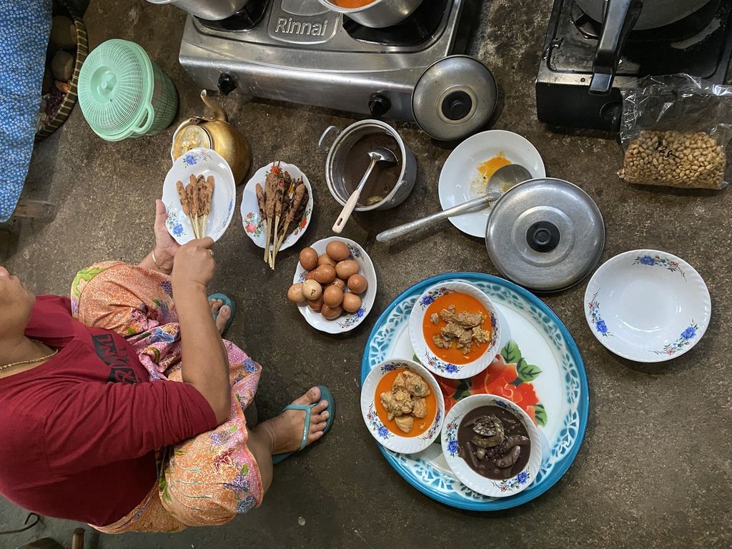 Seorang warga menyiapkan berbagai lauk pauk untuk dibawa ke masjid dan akan disantap atau dimakan bersama atau <i>begibung</i> usai Shalat Idul Fitri di Dusun Kwang Jukut, Desa Pringgarata, Lombok Tengah, Nusa Tenggara Barat, Senin (2/5/2022).