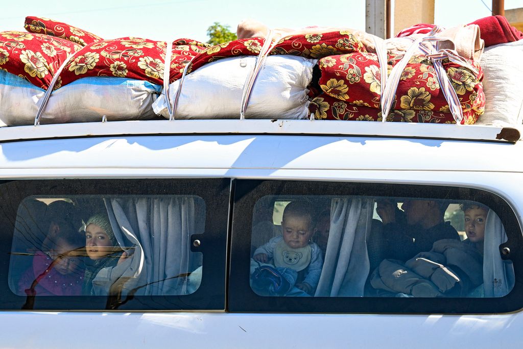 Pengungsi Suriah dan Lebanon mengangkut barang-barang mereka di atas mobil van saat memasuki Suriah dari Lebanon melalui perbatasan Jusiyeh dengan Quseir di Provinsi Homs, Suriah bagian tengah, Rabu (2/10/2024).