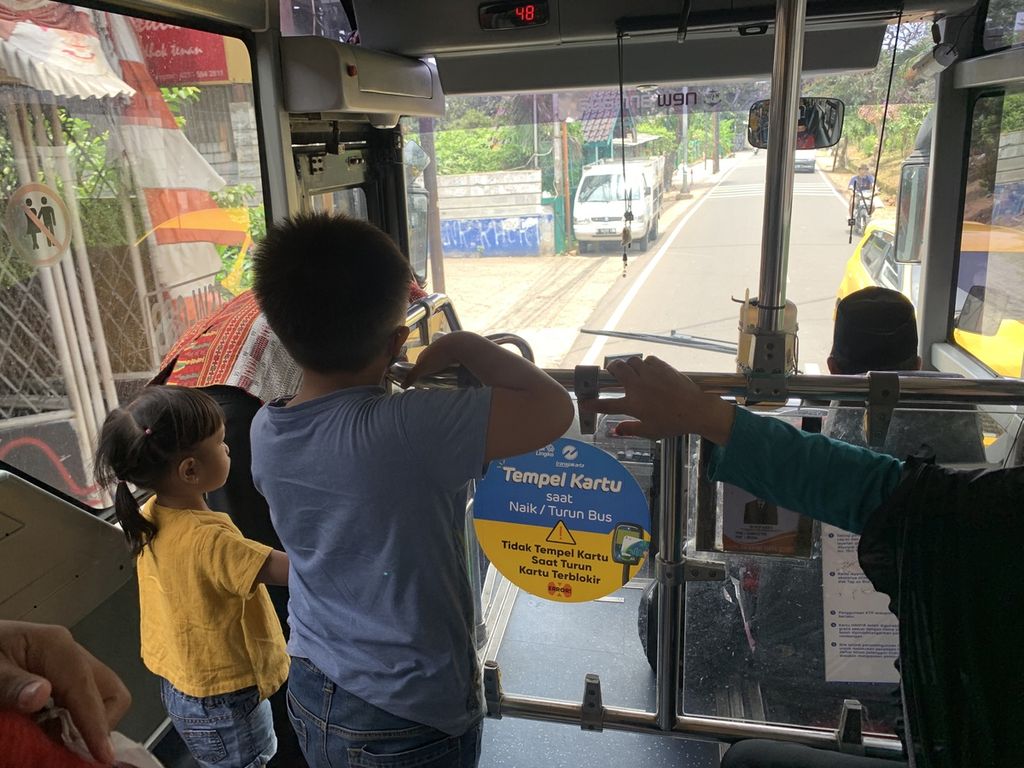 Romy Hutagaol (45) sedang melakukan <i>tap out</i> di bus Transjakarta Koridor 1M, rute Blok M-Meruya, Sabtu (19/11/2022). Mesin tempel kartu di bus tersebut tidak berfungsi dengan baik atau tidak merespons saat penumpang melakukan <i>tap out</i>.