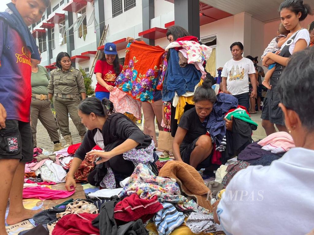 Pengungsi dari Pulau Tagulandang sedang memilih baju dari bantuan donatur di Posko Pengungsian BLK Bitung, Sulawesi Utara, Senin (6/5/2024).