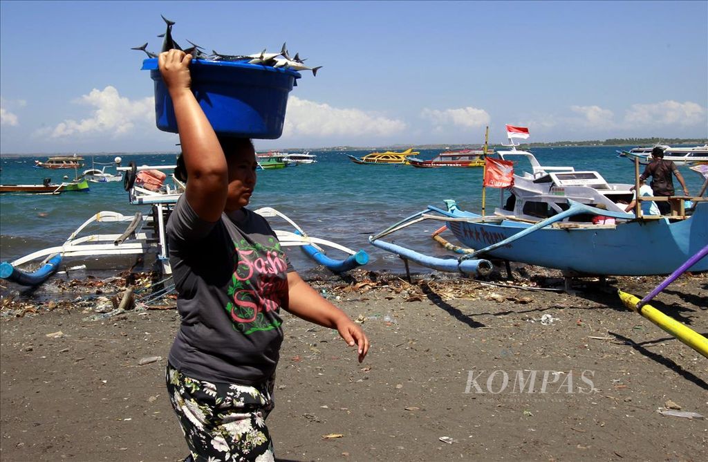 Salah satu aktivitas masyarakat nelayan di Pelabuhan Tanjung Luar, Lombok Timur, Nusa Tenggara Barat, Minggu (3/8/2019). Sebagian perempuan nelayan membawa barang di atas kepala di Pelabuhan Tanjung Luar, Minggu (3/8/2019).