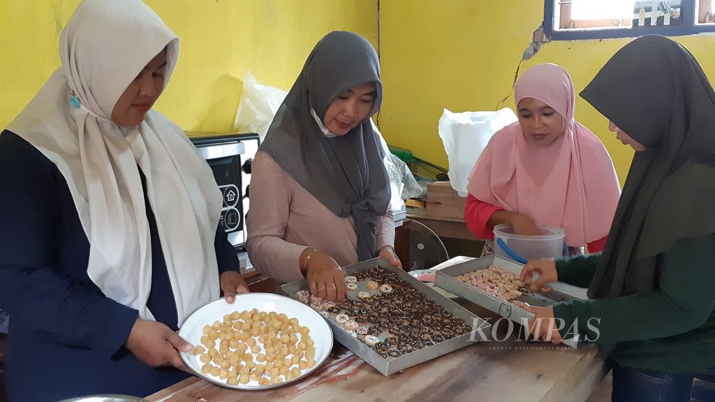 Beberapa mantan pekerja migran asal Desa Wuluhan, Kecamatan Wuluhan, Kabupaten Jember, kini membuat kue kering untuk dijual, Jumat (11/3/2022). Usaha ini bagian dari pemberdayaan ekonomi agar mereka tak tergiur kembali bekerja di luar negeri sebagai pekerja informal.