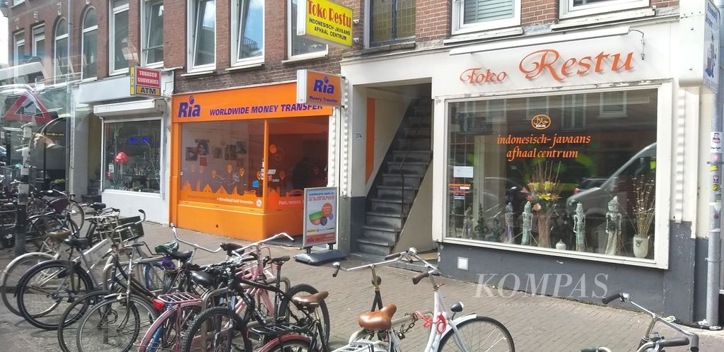 Jalur pedestrian diapit lahan parkir sepeda dan pertokoan di kota Amsterdam, Belanda, yang dijuluki ibu kota sepeda dunia. Foto diambil pada Juli 2019.