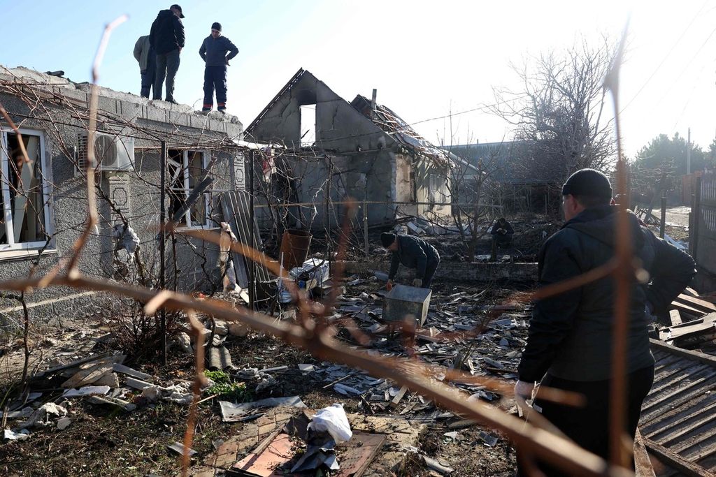 Warga salah satu desa di Odesa, Ukraina, membersihkan dampak serangan udara Rusia pada Minggu (17/12/2023). Rusia meningkatkan serangan udara ke berbagai sarana dan permukiman sipil Ukraina. 