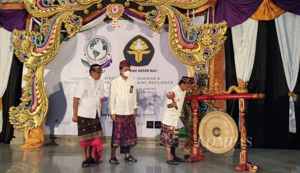 Gubernur Bali Wayan Koster (kanan) memukul gong sebagai tanda pembukaan seminar internasional Green Tourism International Seminar and Entrepreneurship Expo 2022 yang diselenggarakan Program Magister Terapan Perencanaan Pariwisata Politeknik Negeri Bali, Badung, Senin (30/5/2022).