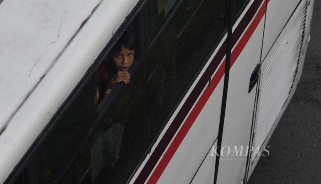 Seorang anak melihat ke arah luar jendela bus antarkota antarprovinsi (AKAP) saat melintasi Tol Jakarta-Cikampek Km 54, Karawang, Jawa Barat, Minggu (8/5/2022). 