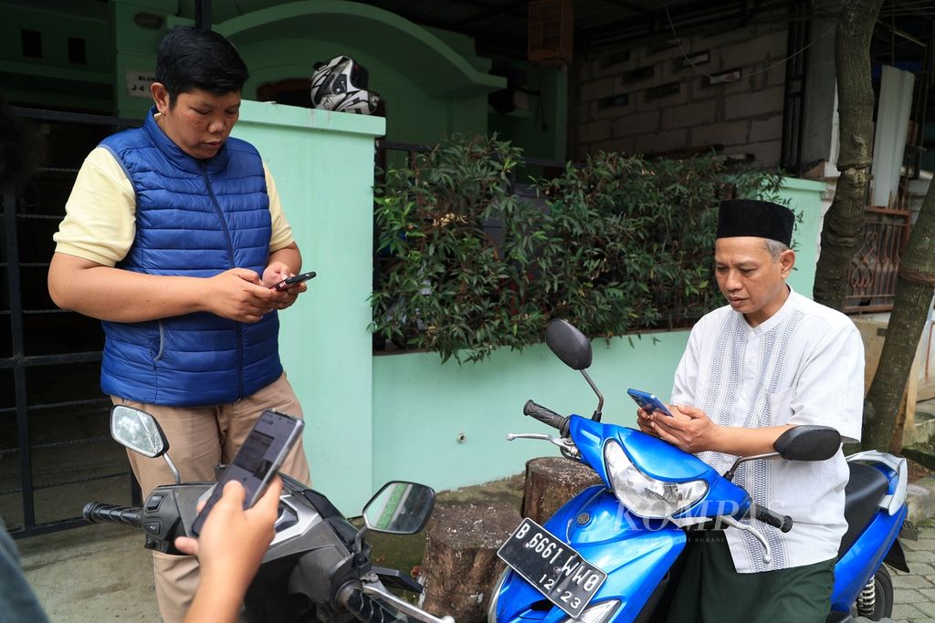 Warga memanfatkan gawainya untuk bertransaksi elektronik ataupun kebutuhan lainnya di kawasan Pamulang, Tangerang Selatan, Banten, Minggu (11/9/2022)