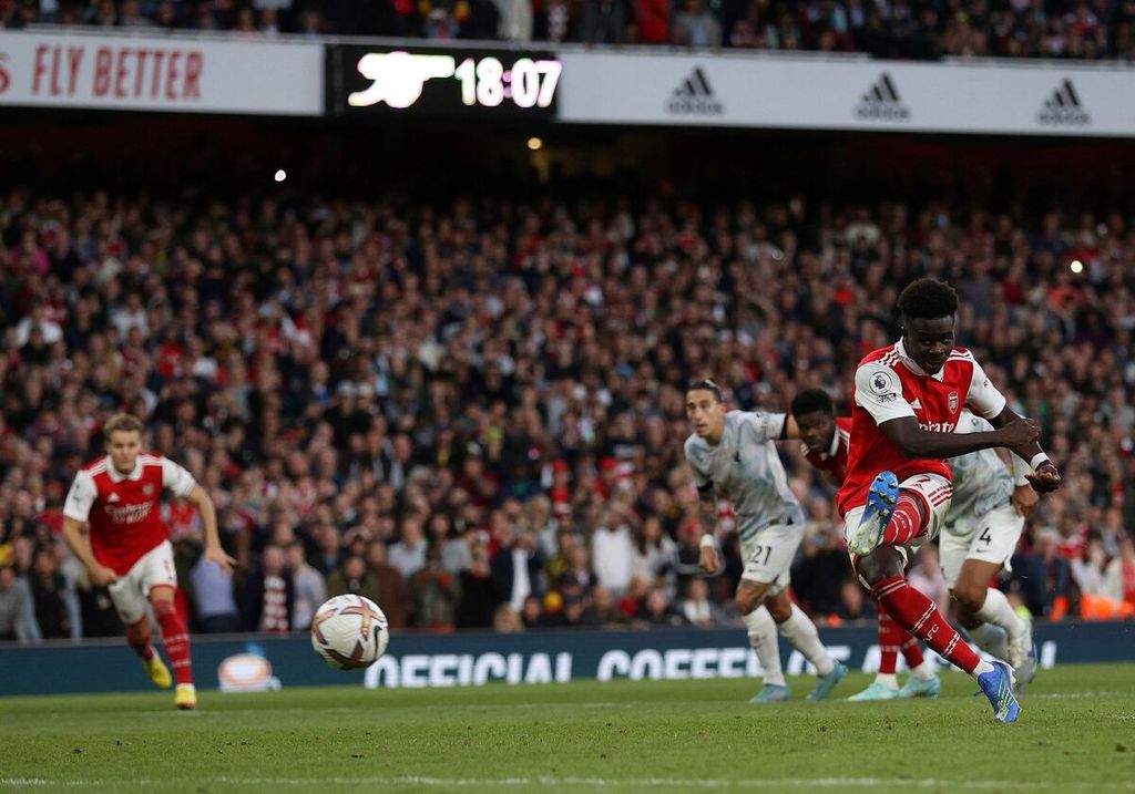 Penyerang sayap Arsenal, Bukayo Saka, mencetak gol dari titik penalti pada laga Liga Inggris di Stadion Emirates, London, Minggu (9/10/2022). 