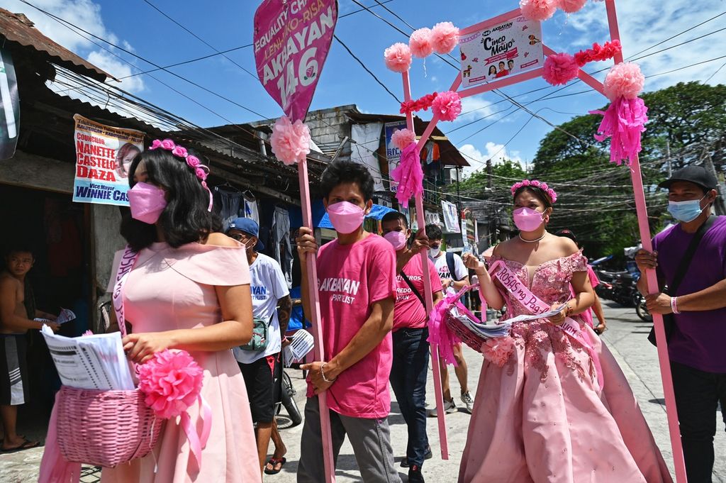 Pendukung kandidat calon presiden Filipina, Leni Robredo, mengenakan gaun berwarna merah muda, mendatangi rumah-rumah warga di Quezon City, Filipina, Kamis (5/5/2022), untuk menarik perhatian para calon pemilih.