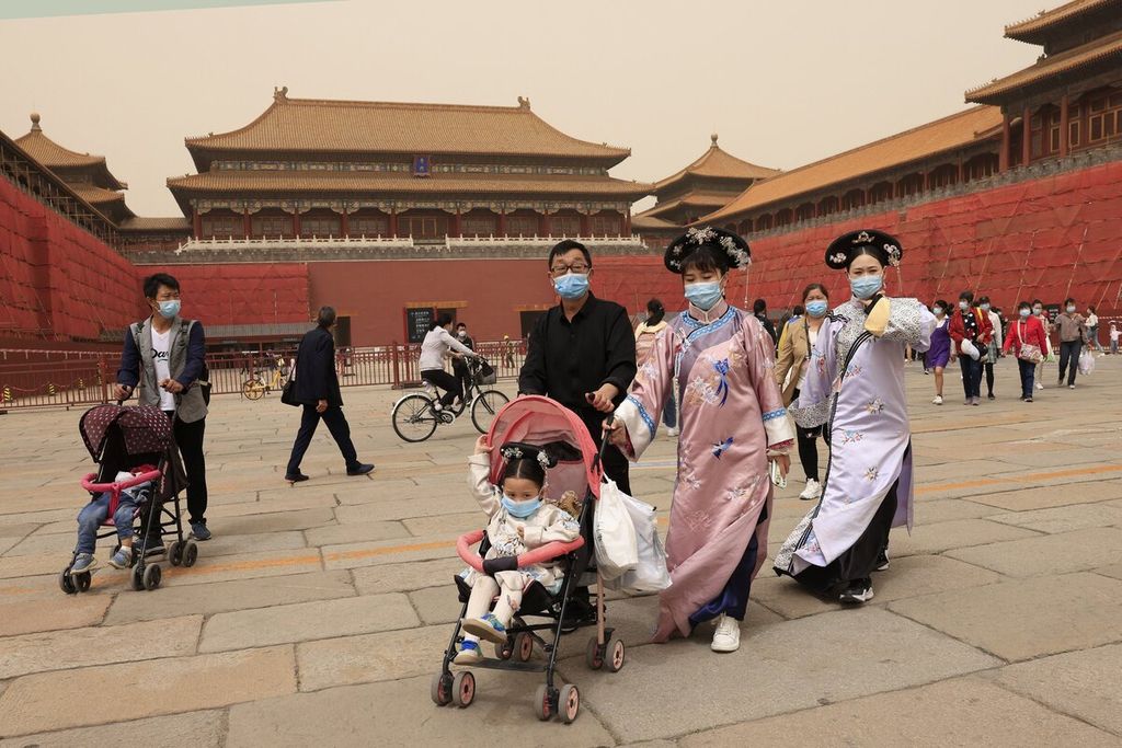 Penduduk yang mengenakan kostum tradisional mengunjungi Kota Terlarang di Beijing, China. Pertumbuhan populasi China turun mendekati nol karena lebih sedikit pasangan yang memiliki anak.