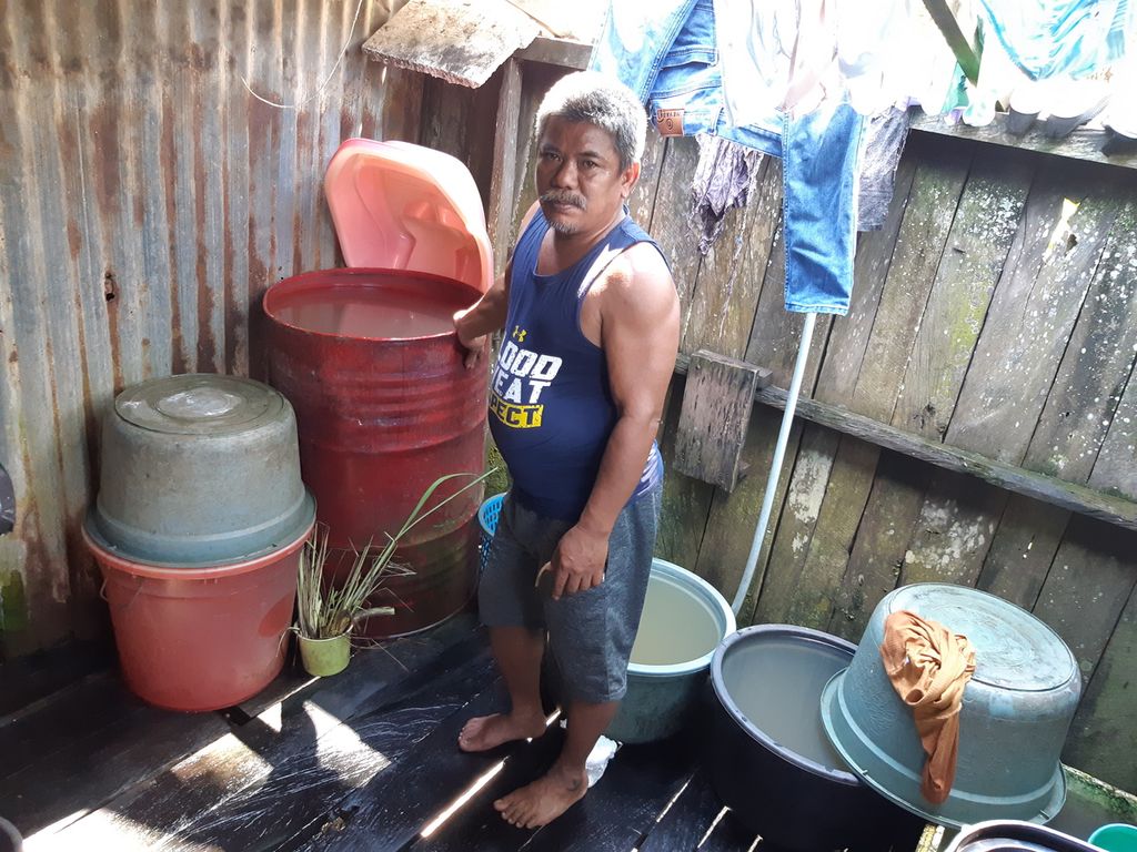 Pandi (49) berdiri di antara bak air yang mereka gunakan untuk mencuci, mandi, dan kakus, di rumahnya di RT 003 Kelurahan Sepaku, Kecamatan Sepaku, Penajam Paser Utara, Kalimantan Timur, Selasa (7/6/2022). Warga di sekitar IKN itu masih kesulitan air bersih untuk dikonsumsi.