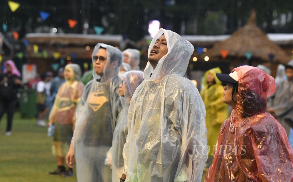 Penonton tetap asyik ikut bernyanyi meski hujan turun di lokasi Joyland Festival 2022 yang berlangsung di Stadion Softball Gelora Bung Karno, Jakarta, Jumat (4/11/2022). Joyland Festival akan berlangsung selama tiga hari hingga Minggu (6/11/2022) ini.