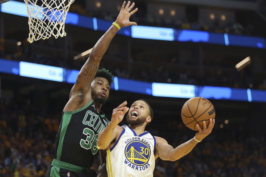 Pemain Golden State Warriors, Stephen Curry (30), berusaha mencetak angka dari hadangan pemain Boston Celtics. Marcus Smart, pada paruh kedua gim kelima final NBA di Chase Center, San Francisco, Selasa (14/6/2022) pagi WIB. 