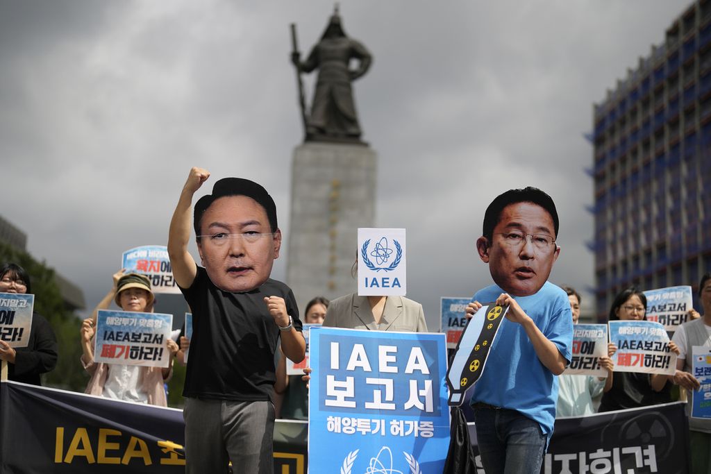 Anggota kelompok sipil yang memakai topeng Perdana Menteri Jepang Fumio Kishida (kanan) dan Presiden Korea Selatan Yoon Suk Yeol berunjuk rasa menentang keputusan pemerintah Jepang untuk melepaskan air radioaktif olahan ke laut dari pembangkit listrik tenaga nuklir Fukushima, di Seoul, Korea Selatan, Rabu (5/7/2023). 