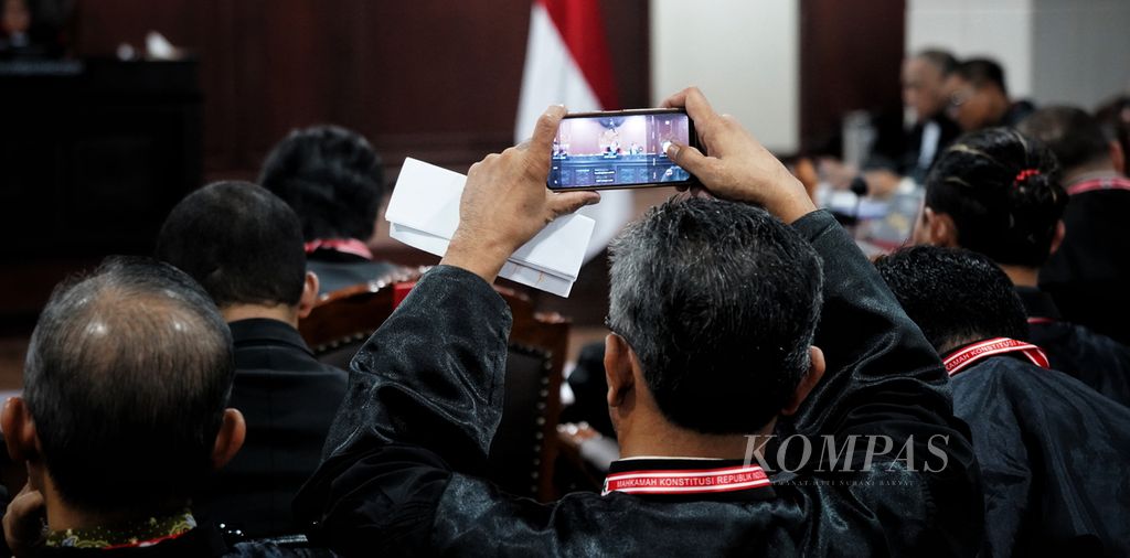 Salah satu kuasa hukum pihak terkait memotret suasana saat digelar sidang perselisihan hasil pemilihan umum pemilihan legislatif panel 3 di Mahkamah Konstitusi, Jakarta, Kamis (2/5/2024).