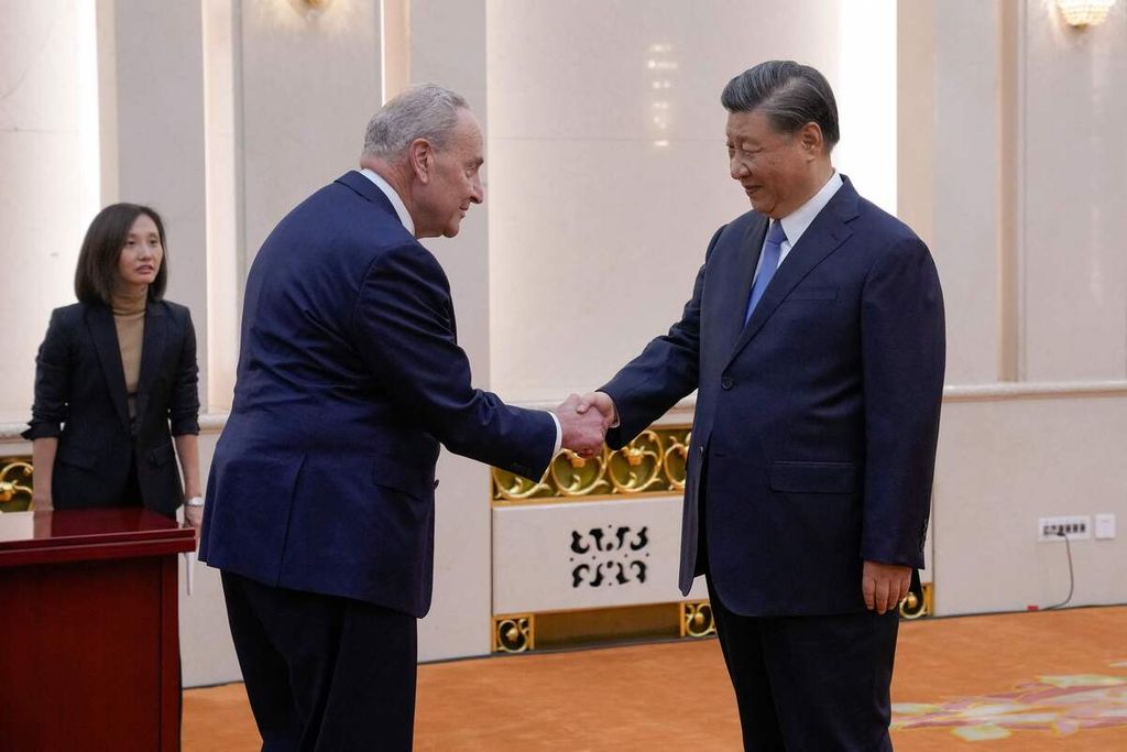 Pemimpin mayoritas Senat AS, Chuck Schumer (kiri), disambut Presiden China Xi Jinping sebelum pertemuan bilateral di Aula Besar Rakyat di Beijing, 9 Oktober 2023. 