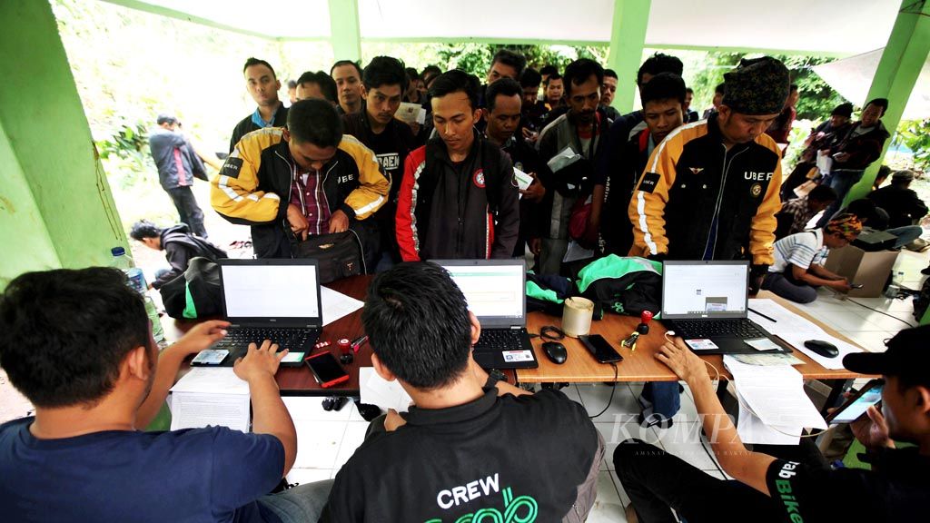Ojek drivers register on Tuesday with ride-hailing services company Grab in Srengseng, West Jakarta. The company is registering all former ojek drivers of Uber following its acquisition of Uber’s Southeast Asian operations.