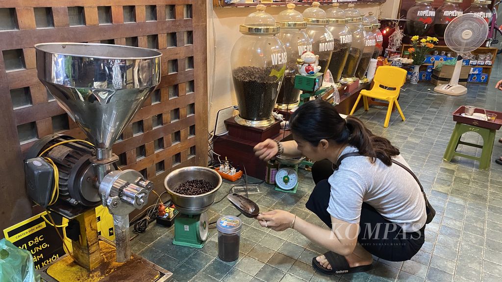Thuy Ha Dang (45), pemilik Coffee Viet Nam Long Thabh, menggiling biji kopi yang sudah disangrai agar menjadi bubuk untuk disajikan dengan teknik seduh <i>vietnam</i><i>drip</i>, Sabtu (14/4/2022). 
