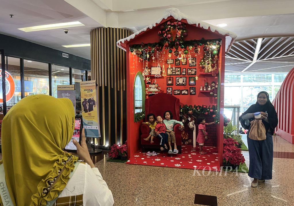 Pengunjung berfoto di dekorasi bernuansa Natal di pusat perbelanjaan di kawasan Tajung Duren, Jakarta Barat, Minggu (10/12/2023).