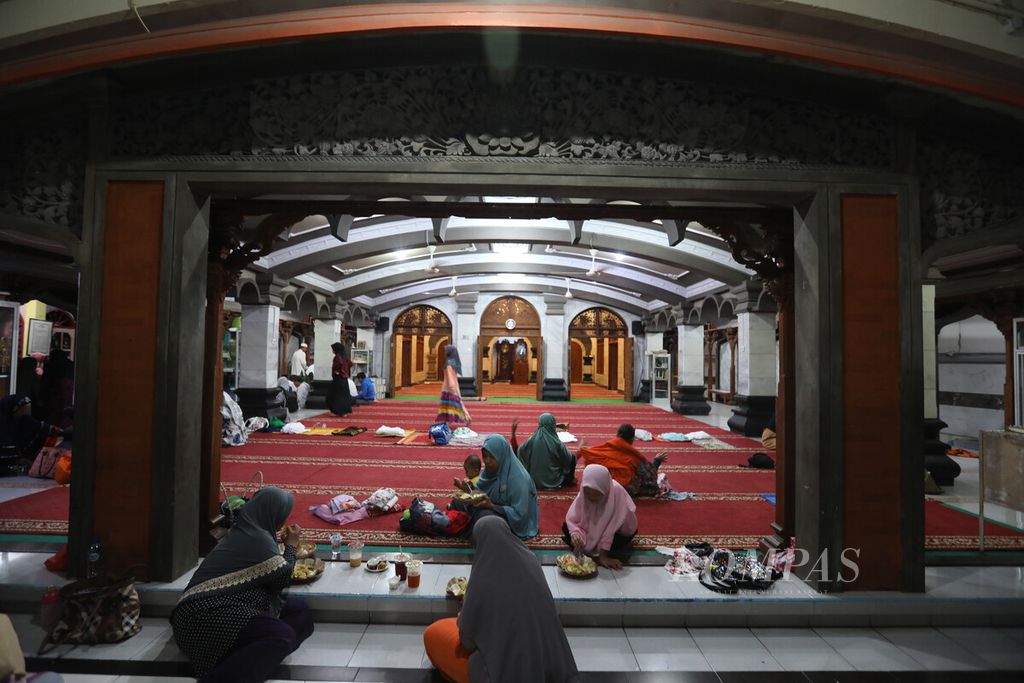 Para anggota jemaah perempuan menyantap buka puasa di serambi depan Masjid Al Hikmah, Kertalangu, Denpasar Timur, Bali, Minggu (2/3/2023). 