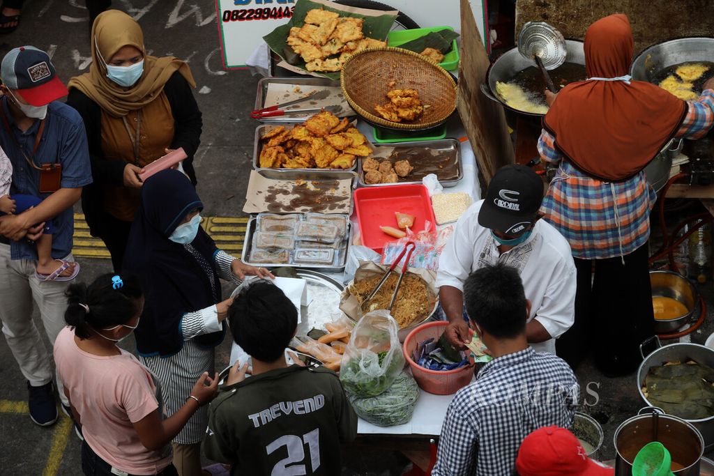 Warga berburu makanan untuk takjil berbuka puasa di Pasar Rawamangun, Jakarta Timur, Rabu (13/4/2021). Pasar takjil ini merupakan salah satu sentra makanan musiman yang ramai dikunjungi warga saat menjelang berbuka puasa. Pedagang pasar takjil musiman memanfaatkan momentum bulan puasa untuk meraup rezeki di tengah pandemi.