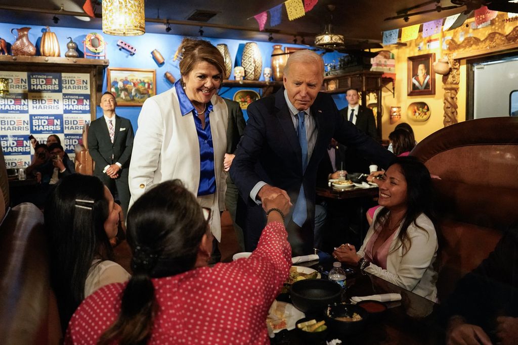 Presiden AS Joe Biden bersama Maritza Rodriguez (berbaju putih), penasihat kampanye tim Biden untuk Negara Bagian Nevada, menyapa masyarakat saat dia tiba di Restoran Lindo Michoacan, di Las Vegas, Nevada, AS, Rabu (17/7/2024).