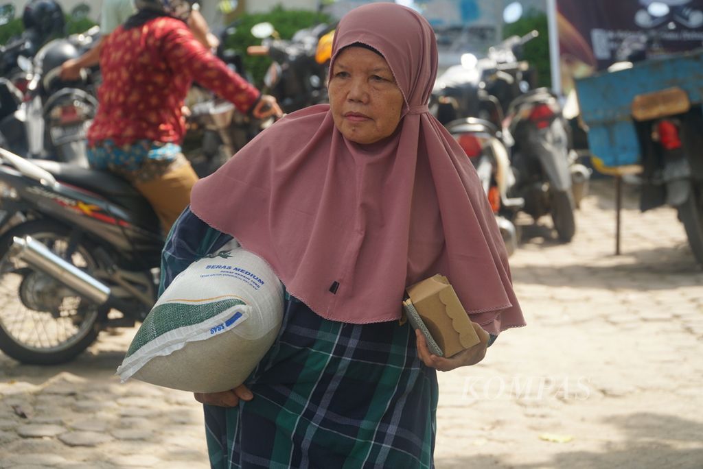 Warga membawa beras bantuan pemerintah yang diambil di kantor Camat Pauh, Kota Padang, Sumatera Barat, Senin (29/1/2024). 