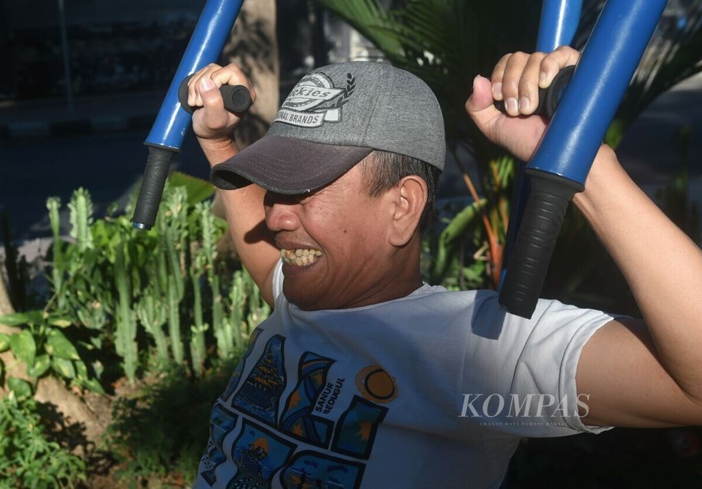Kahar (58) menggunakan sarana olahraga angkat beban yang dibangun di Taman Lansia di Kota Surabaya, Jawa Timur, Minggu (18/8/2019). Taman tersebut dibangun pemerintah kota untuk kebutuhan lansia. Selain sarana olahraga, juga rutin diadakan pemeriksaan kesehatan gratis di taman tersebut.
