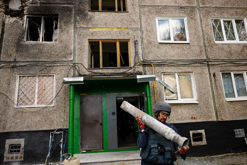 A member of a demining team of the State Emergency Service of Ukraine carries a part of missile following Russian shelling in Kharkiv, eastern Ukraine, on April 28, 2022, on the 64rd day of the Russian invasion of Ukraine. 