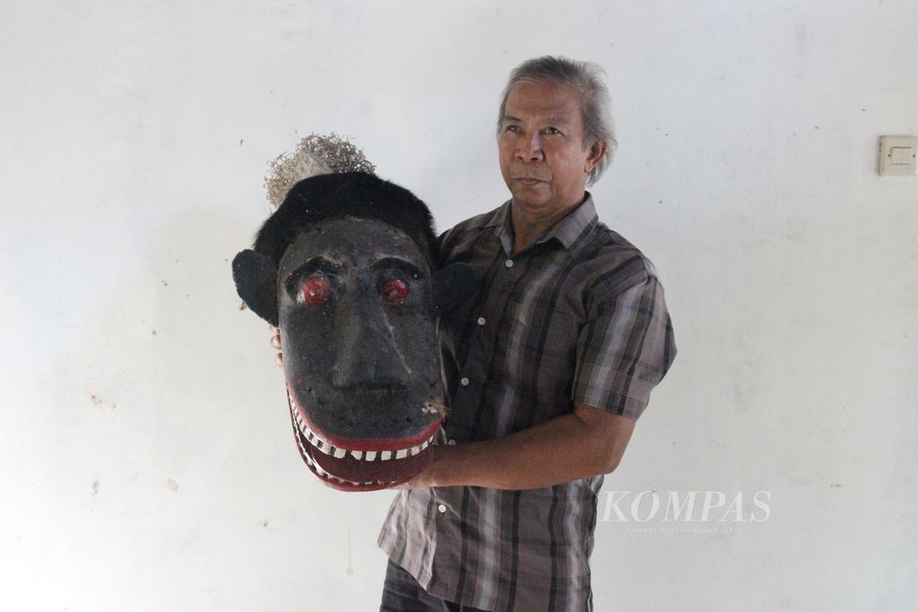 Raimundus Rawas (65), warga Desa Teluk Bakung, Kabupaten Kubu Raya, Kalimantan Barat, menunjukkan topeng Buta yang ia warisi dari orangtuanya, Minggu (22/1/2023).
