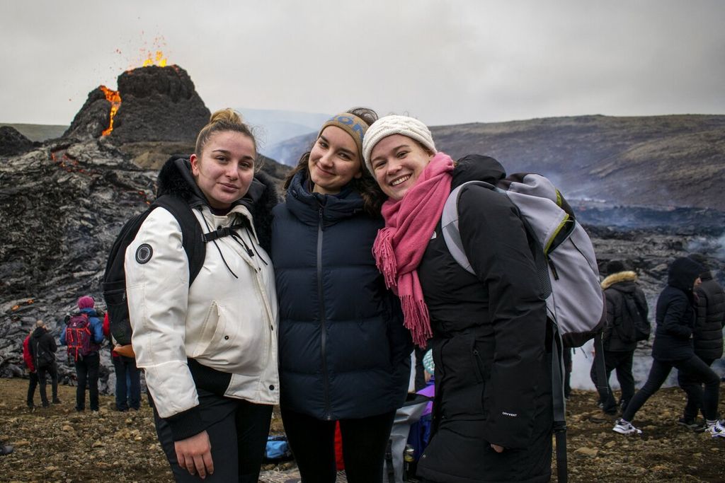 Para pendaki gunung, yaitu (dari kiri ke kanan) Florine Boucher-Locatelli, Pauline Raphanel, dan Milie Saint-Mleux, berpose dengan latar belakang gunung berapi Fagradalsfjall, Eslandia, 21 Maret 2021. Mereka memanfaatkan waktu akhir pekan untuk melihat aliran lahar dari letusan gunung di Semenanjung Reykjanes yang sudah lama tidak aktif, tetapi meletus kembali itu. 