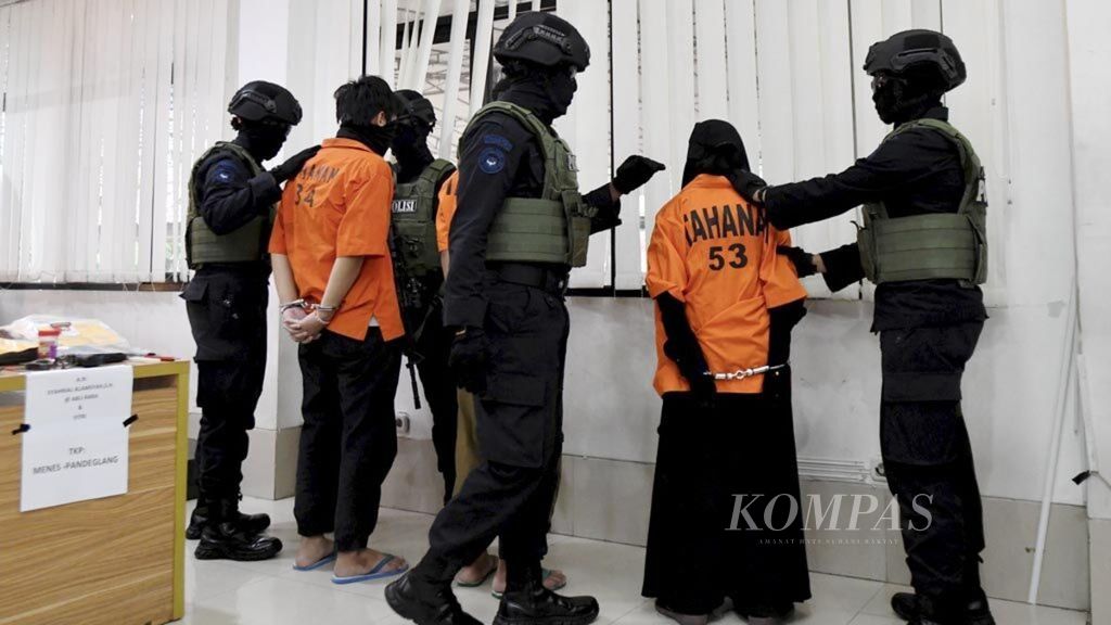 Petugas Densus 88 Antiteror Polri membawa sejumlah terduga pelaku tindak terorisme saat rilis pengungkapan jaringan terorisme di Mabes Polri, Jakarta, Kamis (17/10/2019).