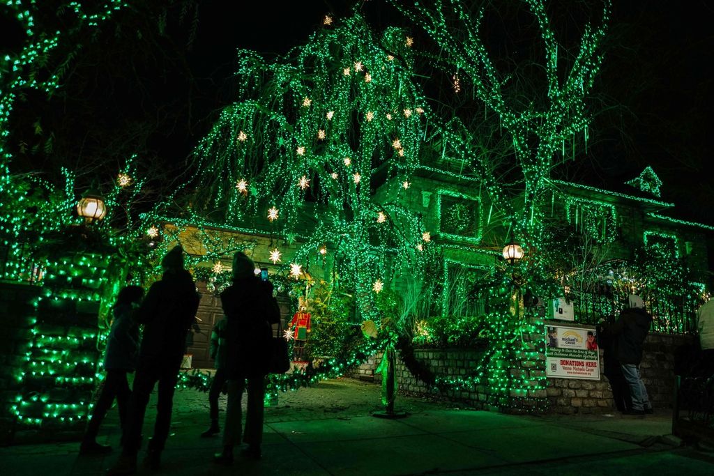 Orang-orang melihat rumah-rumah yang dihiasi dekorasi dan lampu-lampu natal di kawasan Dyker Heights, Brooklyn, New York, AS, pada 20 Desember 2023,  
