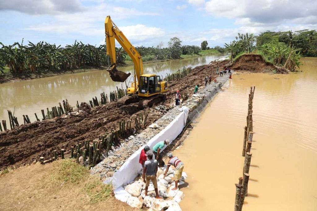 Alat berat diturunkan untuk memperbaiki tanggul sungai yang jebol di Kebumen, Jawa Tengah, Selasa (3/11/2020).