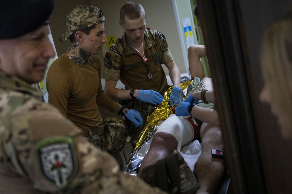 Sejumlah tenaga medis lapangan tengah merawat seorang prajurit di sebuah lokasi di Donetsk, Kamis (7/6/2022).