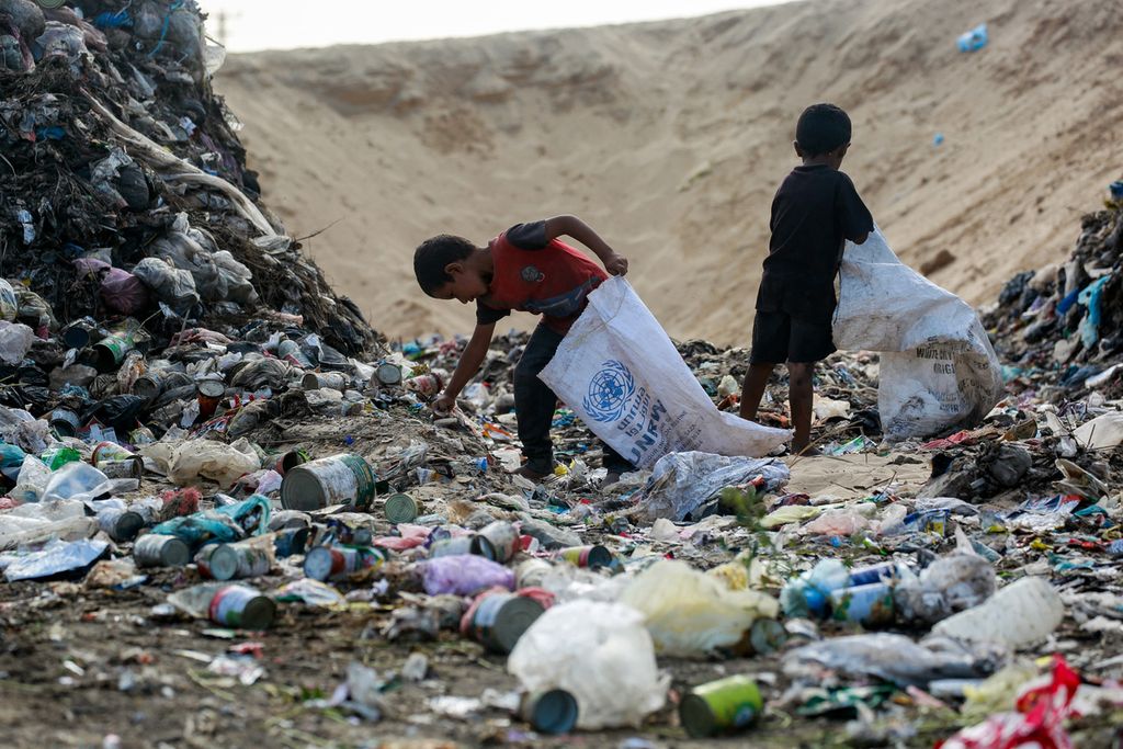 Anak-anak Palestina tengah mencari barang bekas di tumpukan sampah di Khan Younis, Gaza, Selasa (15/10/2024). 